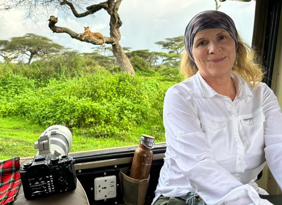 Woman photographing wildlife on African safari, reflecting a life beyond corporate structure and a freedom-based lifestyle.